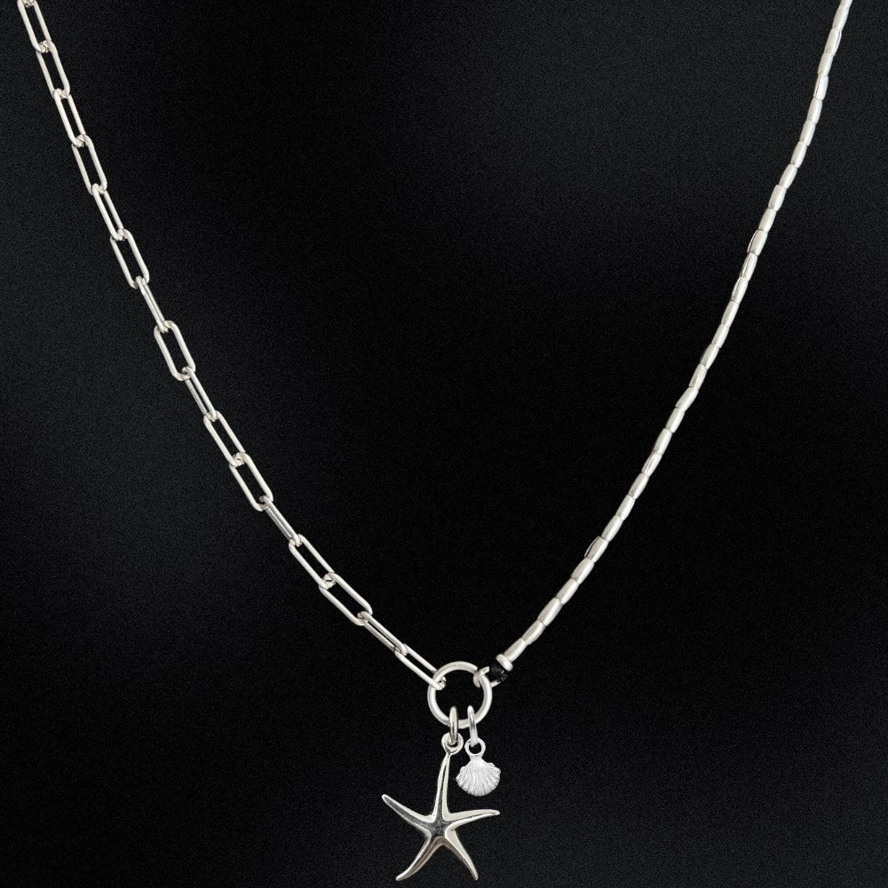 Silver necklace with a starfish pendant on a black background