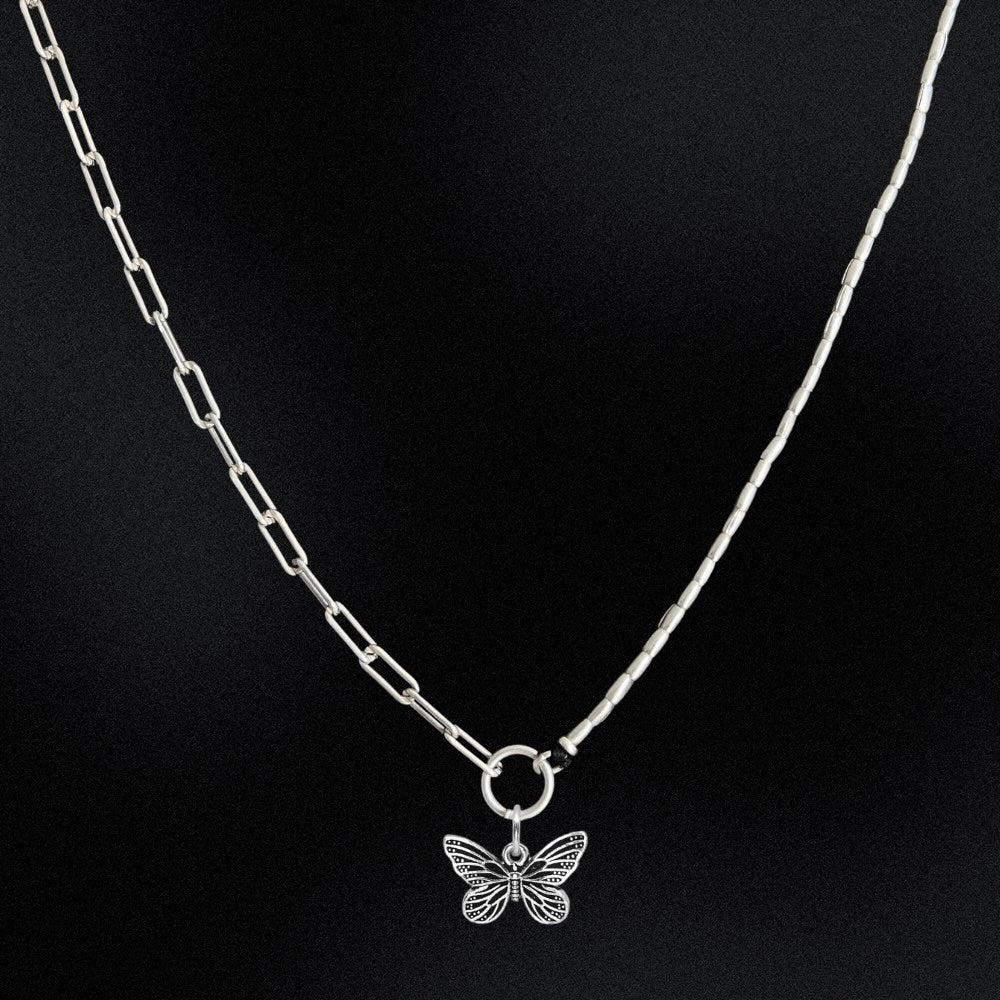 Silver butterfly pendant necklace on a black background