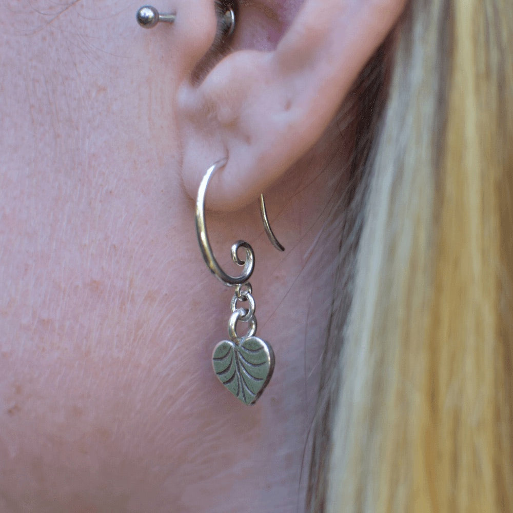 Crafted from high-quality sterling silver, these earrings feature a unique swirl earring hook design, giving them an eye-catching and contemporary look.  At the end of each earring hook, you'll find a beautifully crafted heart-shaped leaf charm. These charming leaves have been designed with incredible detail, and are sure to add a touch of nature-inspired elegance to your outfit.