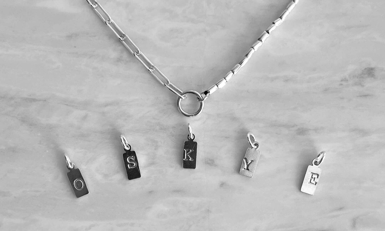 Necklace with letter charms on a marble surface