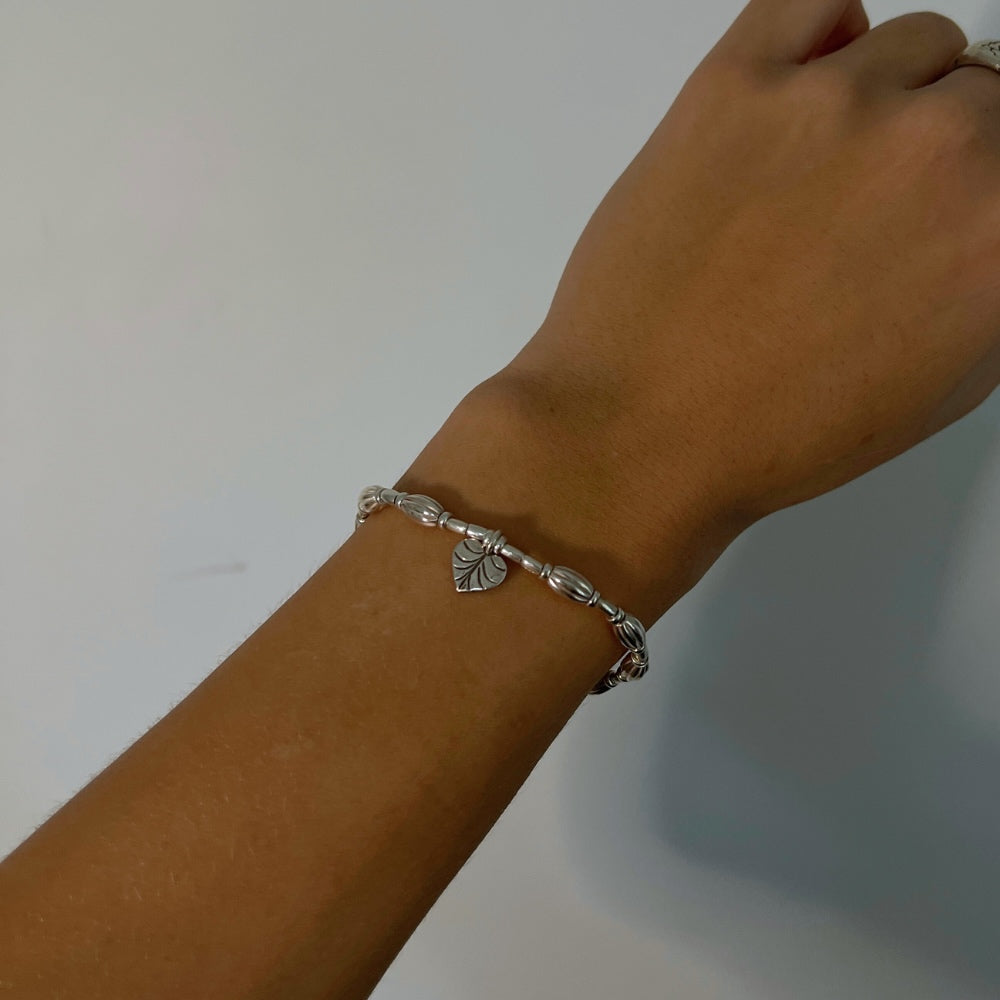 A true work of art. Handcrafted with intricate detail, this bracelet features a heart leaf charm at its centrepiece that is sure to capture your heart. The charm is complemented by corrugated beads that add a textural element to the bracelet.  Crafted from high-quality Hill Tribe Silver, the delicate balance of the charm and the beads brings together a perfect harmony of nature and artistry that is sure to make you stand out from the crowd.