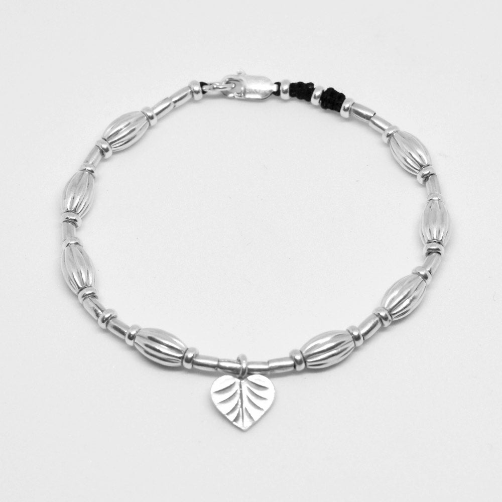 A true work of art. Handcrafted with intricate detail, this bracelet features a heart leaf charm at its centrepiece that is sure to capture your heart. The charm is complemented by corrugated beads that add a textural element to the bracelet.  Crafted from high-quality Hill Tribe Silver, the delicate balance of the charm and the beads brings together a perfect harmony of nature and artistry that is sure to make you stand out from the crowd.