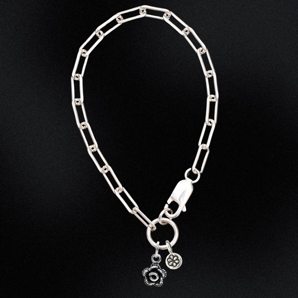 Silver chain bracelet with charms on a black background