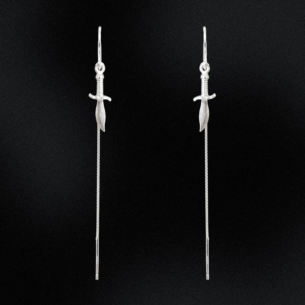 Pair of silver sword-shaped earrings on a black background