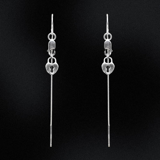 Pair of silver lock-shaped earrings on a black background
