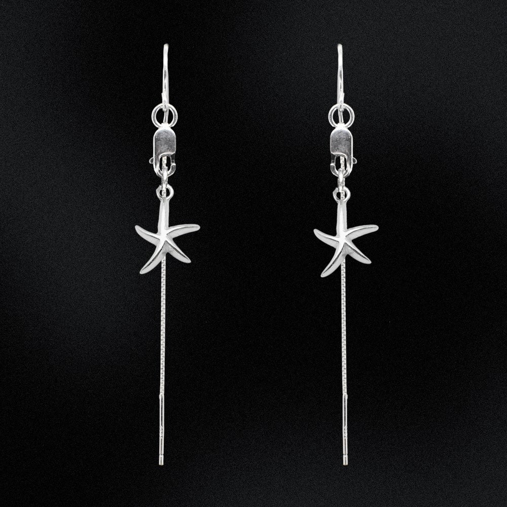 Silver starfish earrings on a black background