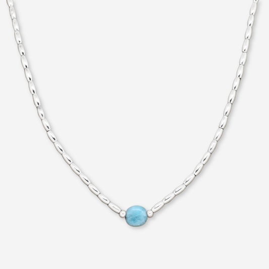 Necklace with a blue gemstone on a white background
