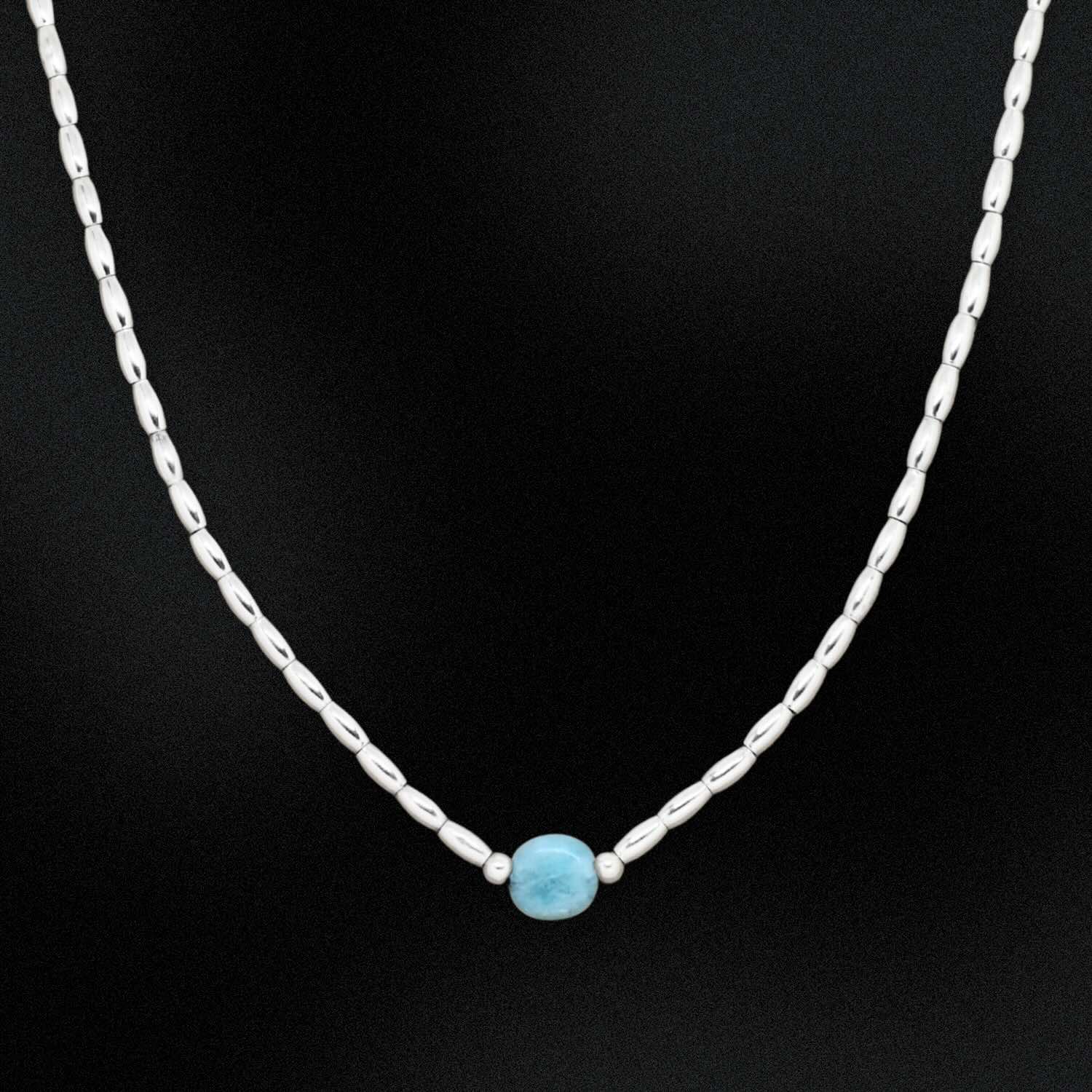 Necklace with a blue larimar stone on a black background