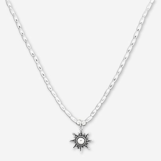Silver necklace with a sun pendant on a white background