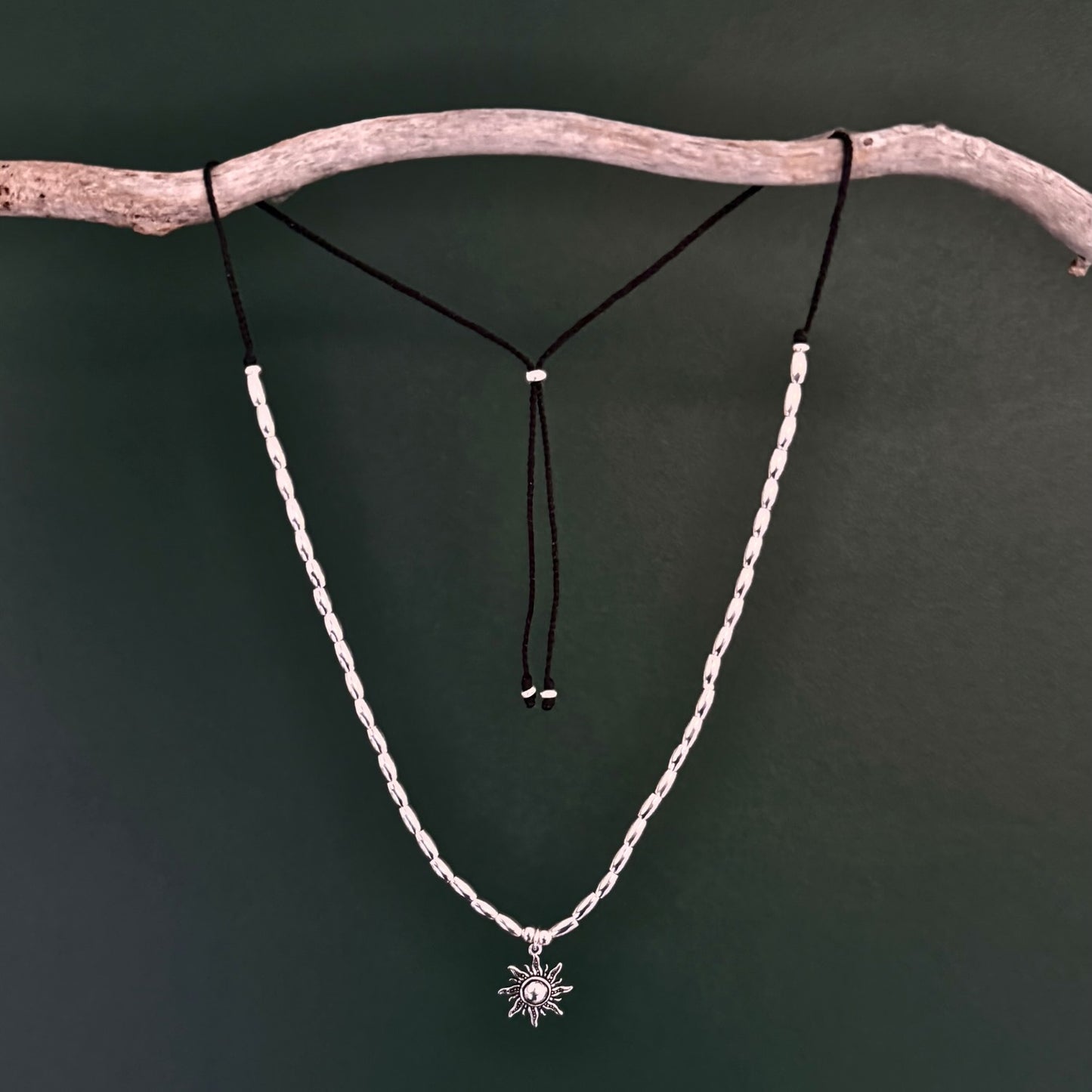Necklace with a star pendant on a branch against a dark background