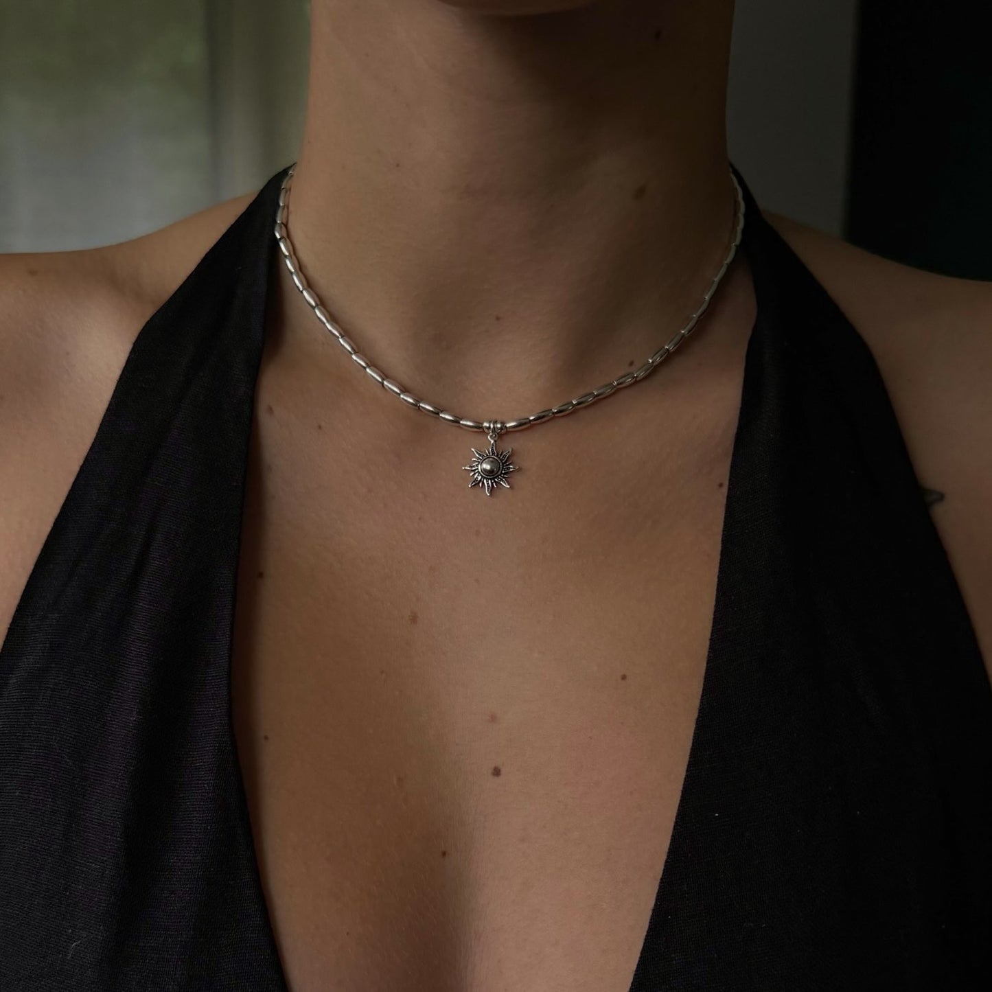 Necklace with a star pendant worn by a person against a dark background