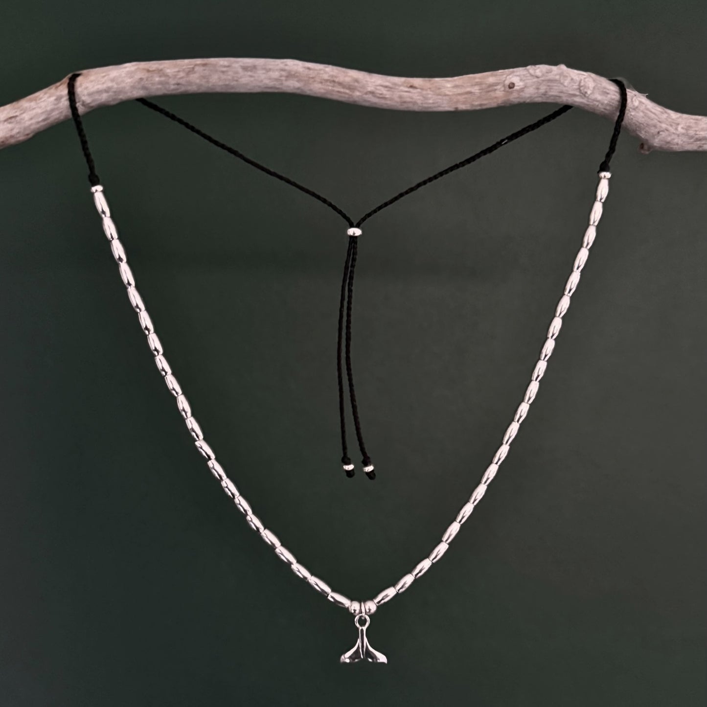Silver necklace with a pendant on a dark background