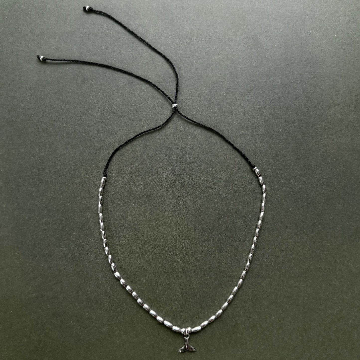 Necklace with a small pendant on a dark gray background