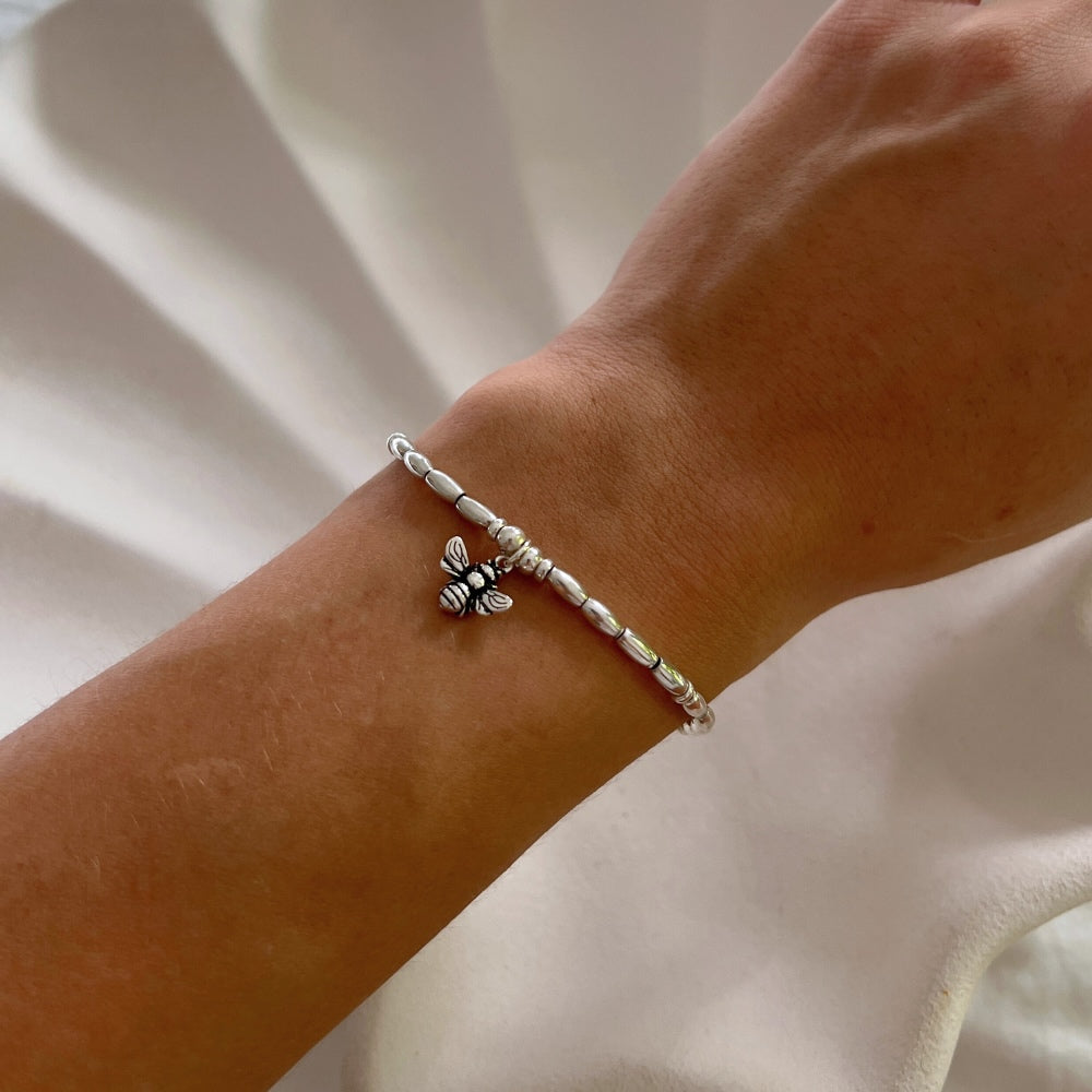 Embrace the beauty and energy of nature with our Bee Charm Sterling Silver Beaded Bracelet. Handcrafted with sterling silver beads on a durable wax string, this bracelet showcases a charming bee motif at its center. Perfect for adding a touch of whimsy and elegance to any outfit. Buzz into style with this charming bracelet!