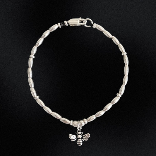 Embrace the beauty and energy of nature with our Bee Charm Sterling Silver Beaded Bracelet. Handcrafted with sterling silver beads on a durable wax string, this bracelet showcases a charming bee motif at its center. Perfect for adding a touch of whimsy and elegance to any outfit. Buzz into style with this charming bracelet!