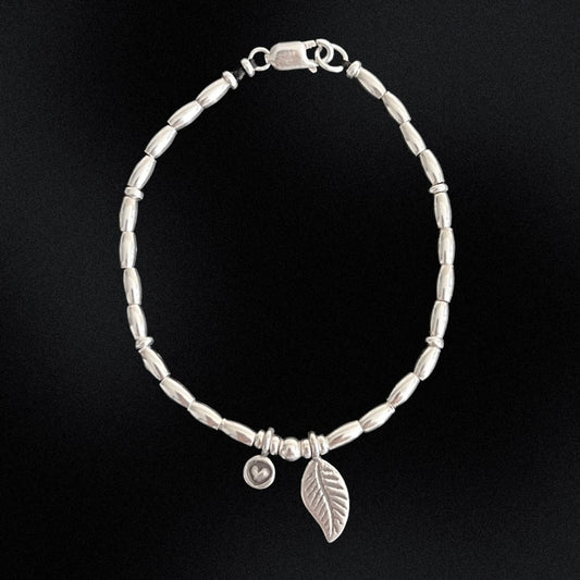Get inspired by our Leafy Love Charm Silver Beaded Bracelet! Hand-crafted with sterling silver beads and wax string, this bracelet flaunts a sweet little heart charm and a centre leaf charm. Show your love for fashion and nature with this one-of-a-kind accessory.