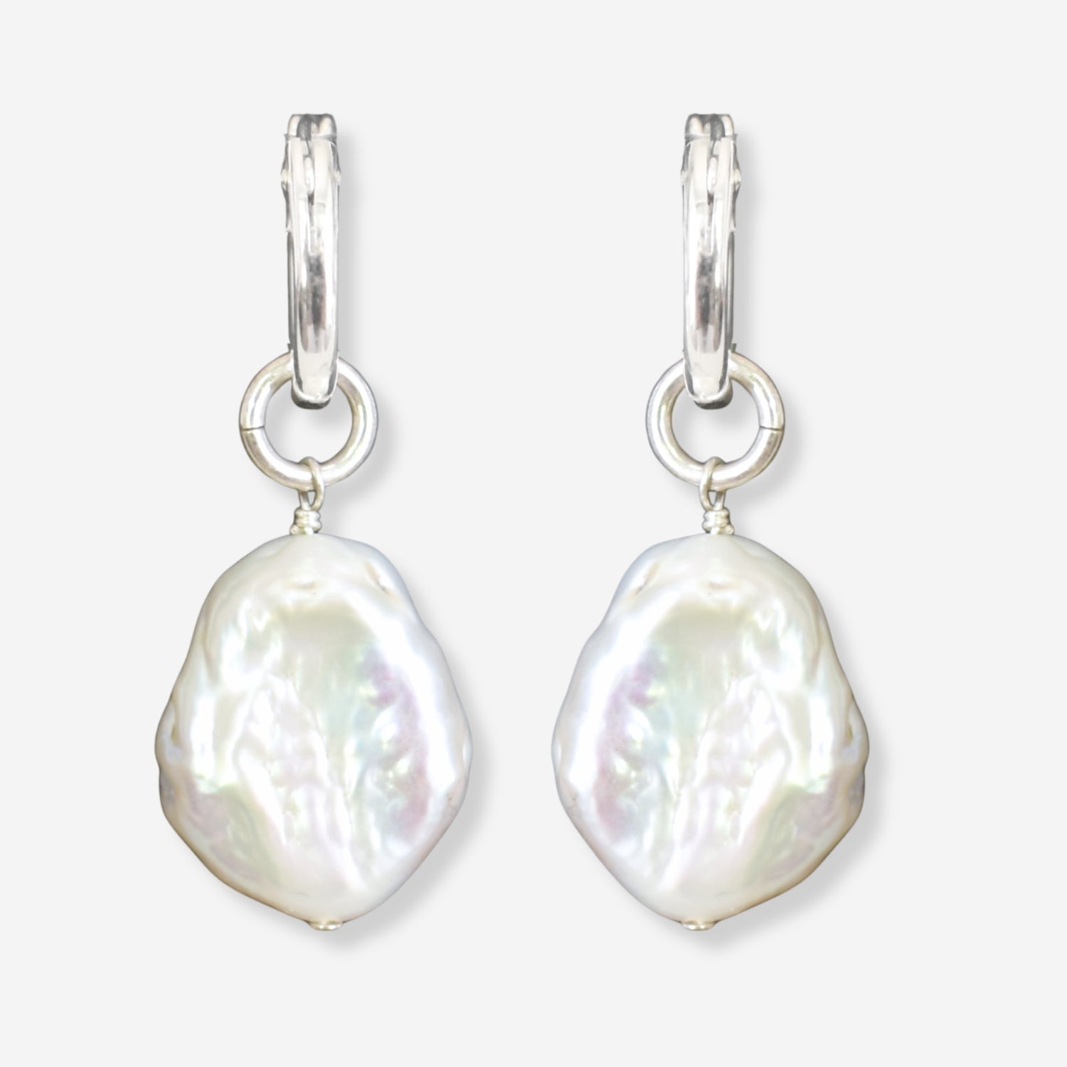 Pearl earrings with silver hooks on a light gray background