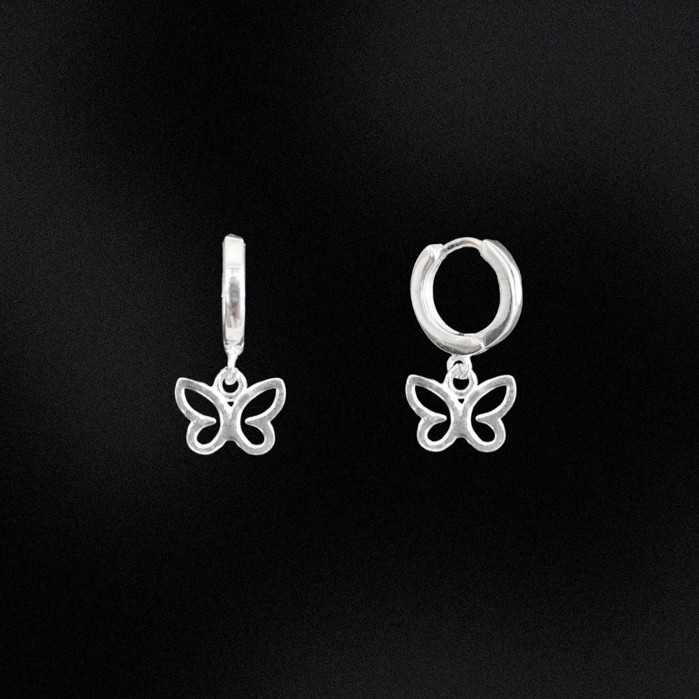Butterfly-shaped silver earrings on a black background