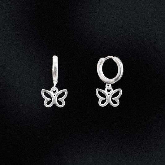 Butterfly-shaped silver earrings on a black background