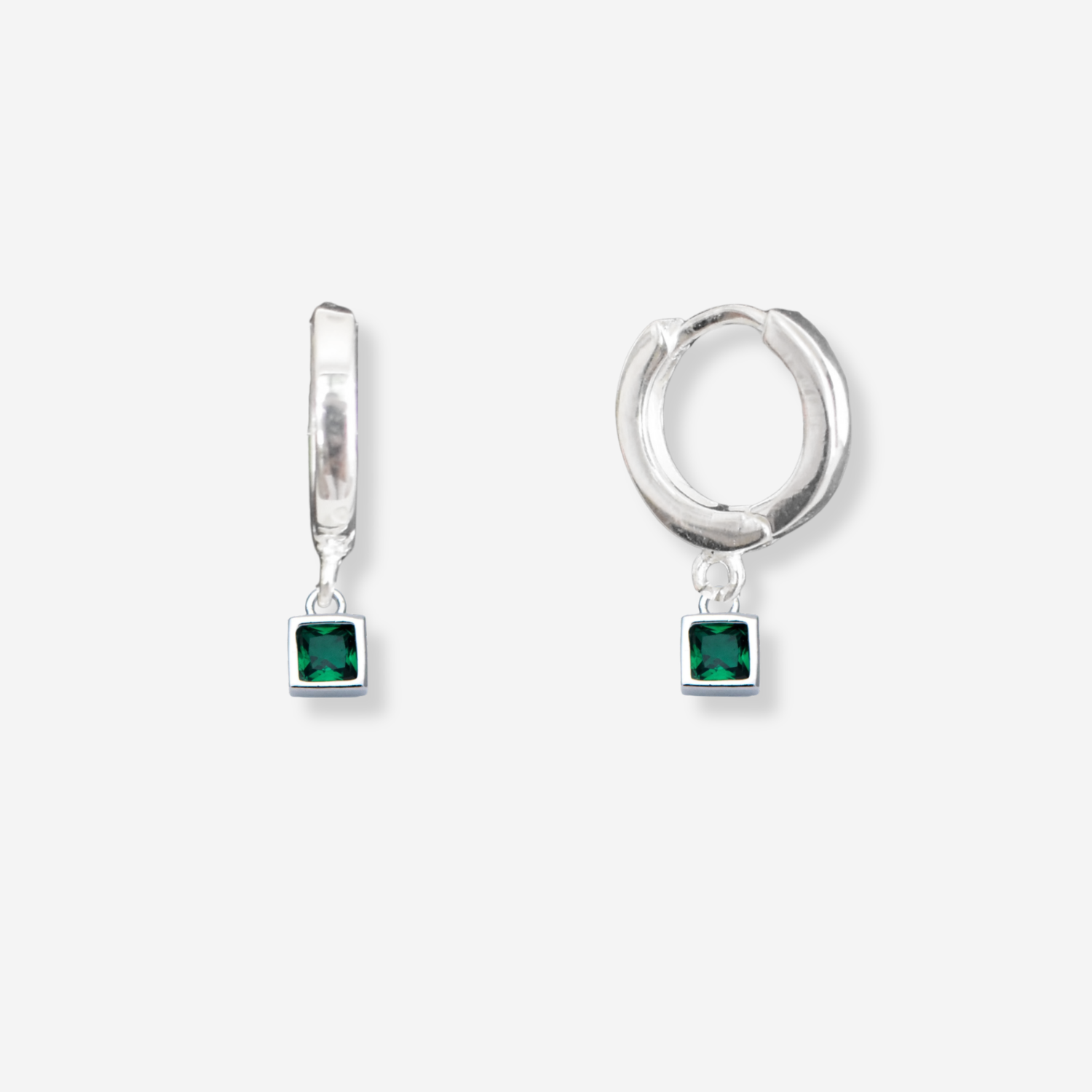 Silver hoop earrings with green gemstones on a white background