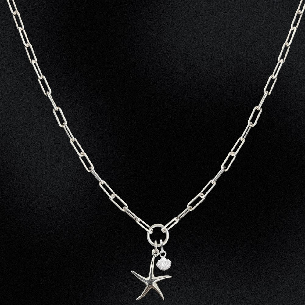 Silver chain necklace with starfish pendant on a black background
