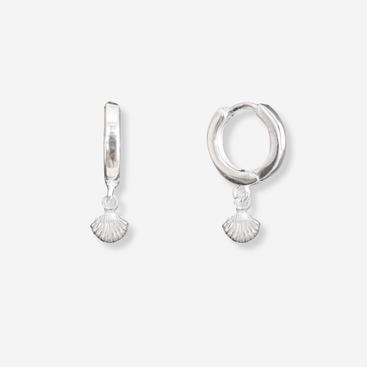 Pair of silver hoop earrings with shell charms on a white background