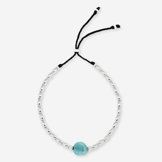 Bracelet with a turquoise bead on a white background