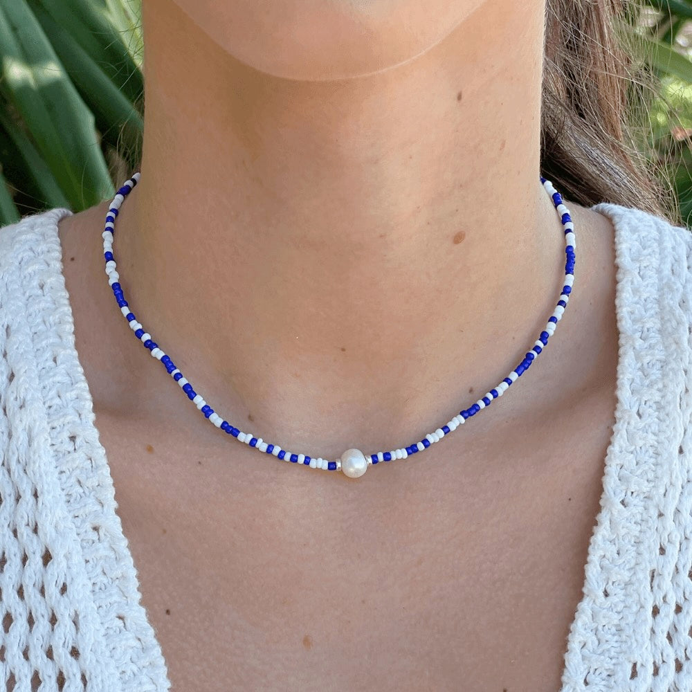 Capture the elegance of the Greek Isles with our Santorini Blue & White Choker. This charming piece features a unique combination of blue and white beads, flawlessly handcrafted for a timeless style that shines with every wear. Elevate your look with this classic and delicate statement piece!