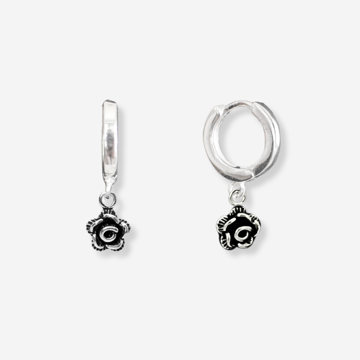 Silver hoop earrings with rose charms on a white background