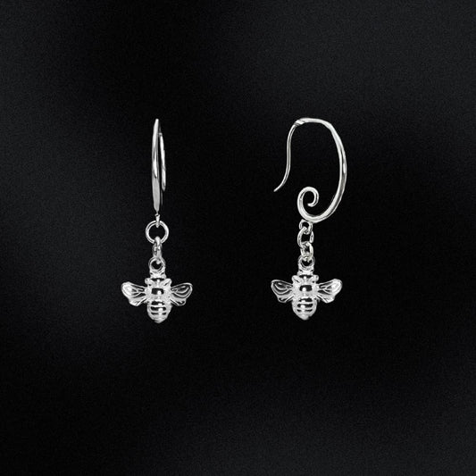 Silver bee earrings on a black background