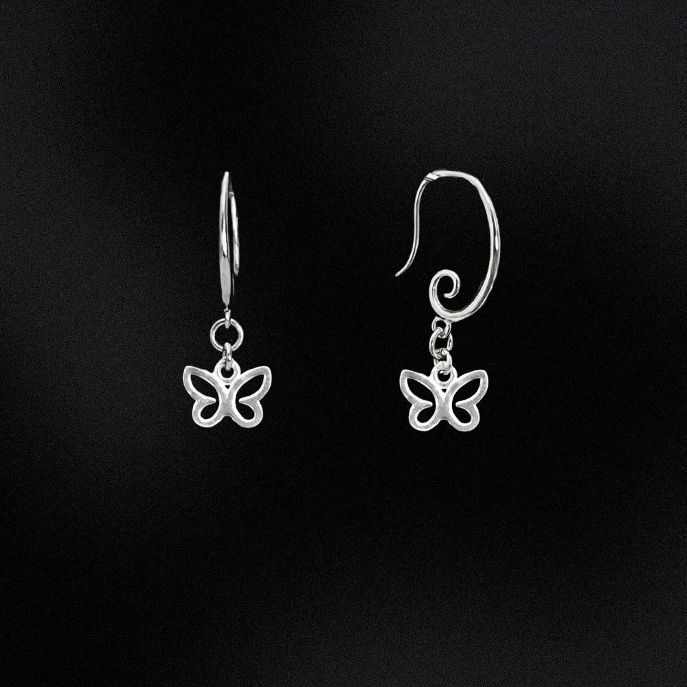 Butterfly-shaped silver earrings on a black background