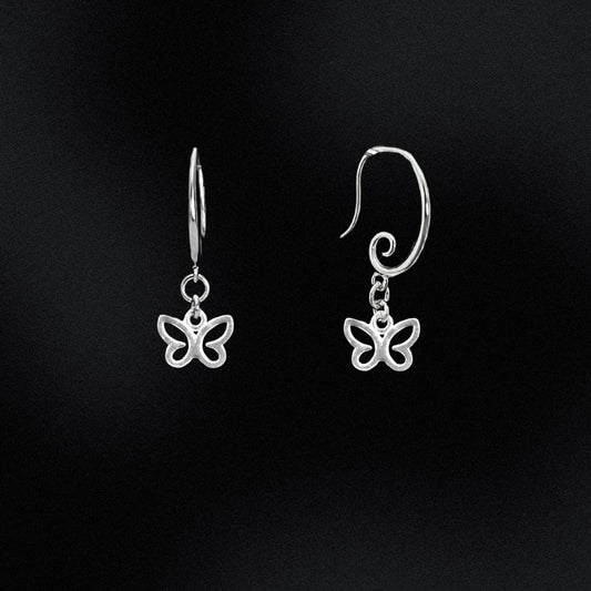 Butterfly-shaped silver earrings on a black background