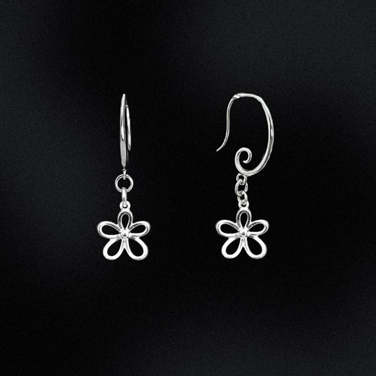 Silver flower-shaped earrings on a black background