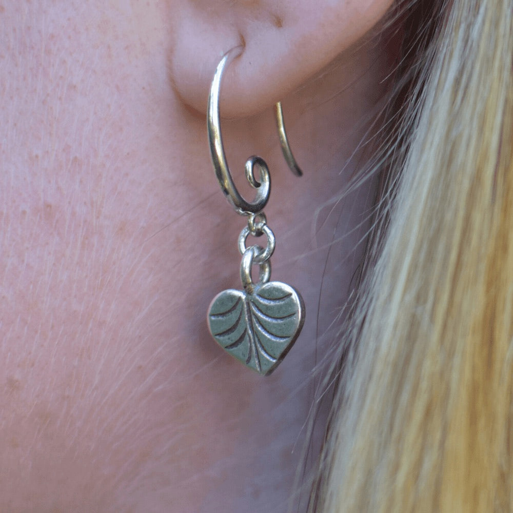 Crafted from high-quality sterling silver, these earrings feature a unique swirl earring hook design, giving them an eye-catching and contemporary look.  At the end of each earring hook, you'll find a beautifully crafted heart-shaped leaf charm. These charming leaves have been designed with incredible detail, and are sure to add a touch of nature-inspired elegance to your outfit.