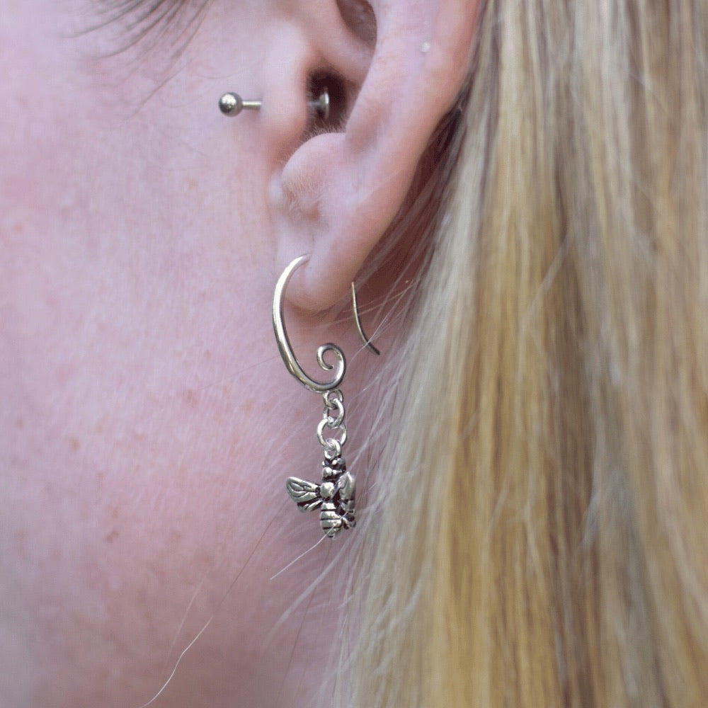 The earring hook boasts a unique and elegant swirl design, providing a modern and stylish touch to these timeless pieces. But what truly makes these earrings stand out is the delicate honey bee that dangles from the earring hook. The bee is meticulously crafted to ensure an accurate representation of this important and symbolic creature.  These earrings are versatile enough to complete any outfit. 