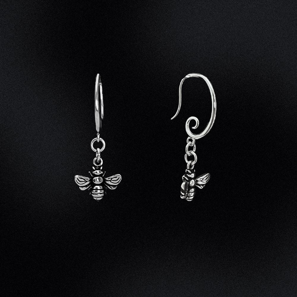 The earring hook boasts a unique and elegant swirl design, providing a modern and stylish touch to these timeless pieces. But what truly makes these earrings stand out is the delicate honey bee that dangles from the earring hook. The bee is meticulously crafted to ensure an accurate representation of this important and symbolic creature. These earrings are versatile enough to complete any outfit.