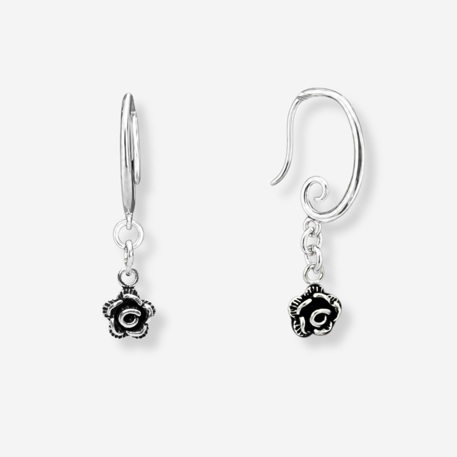 Pair of silver earrings with floral designs on a white background