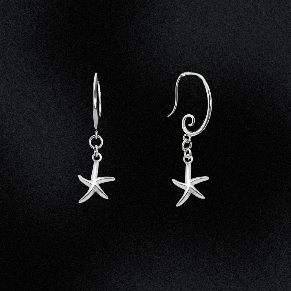 Silver starfish earrings on a black background