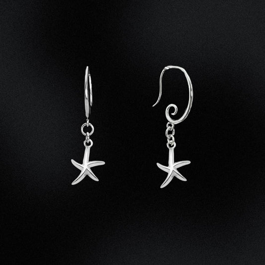 Silver starfish earrings on a black background