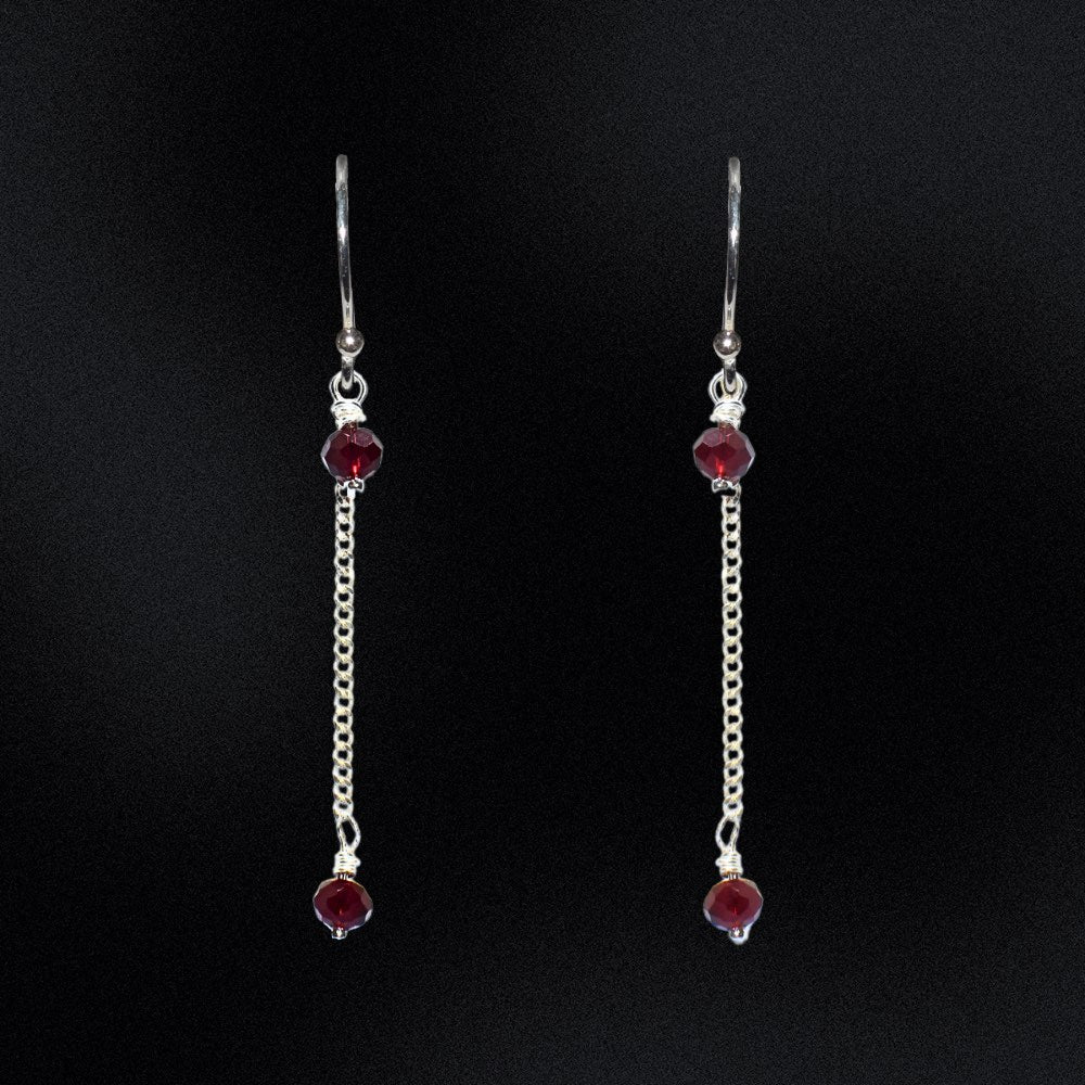 These earrings are a stunning addition to any wardrobe, perfect for adding a touch of elegance to any outfit. The earrings are made from high-quality sterling silver, ensuring their durability and long-lasting beauty. The earrings feature faceted glass rondelle beads in ruby red that are hung from a curb chain. The black beads are absolutely striking against the sterling silver and the chain adds a unique and modern twist to these timeless earrings.