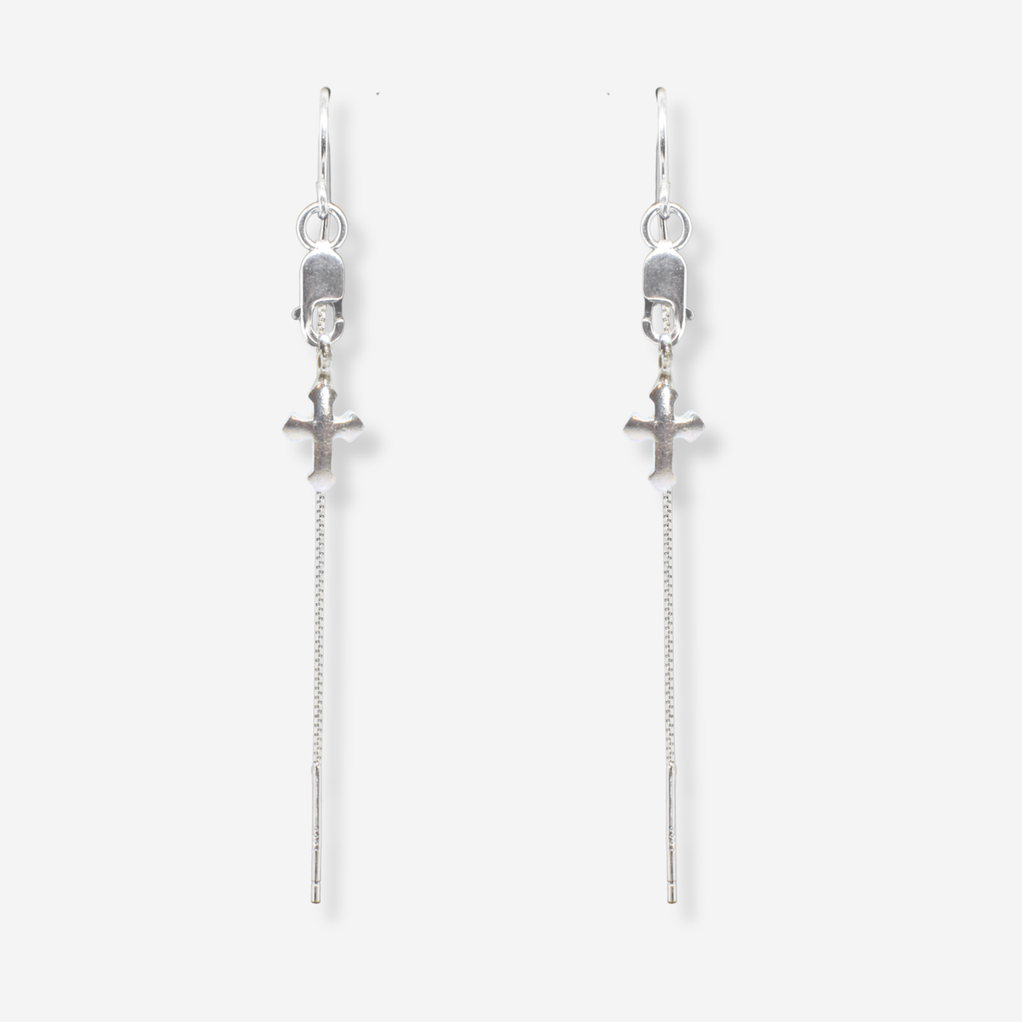 Pair of silver cross earrings with chain drops on a white background