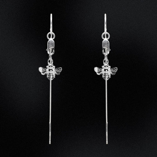 Bee Bold - Silver Thread Earrings are the perfect addition to any wardrobe. Crafted from sterling silver, they feature a delicate bee charm, suspended from a lobster clasp and lightweight threaders, making them a timeless and elegant choice.  They are comfortable to wear and guaranteed to start a conversation. Add a modern touch to your look with this stunning piece of jewellery that is perfect for everyday or a special night out.
