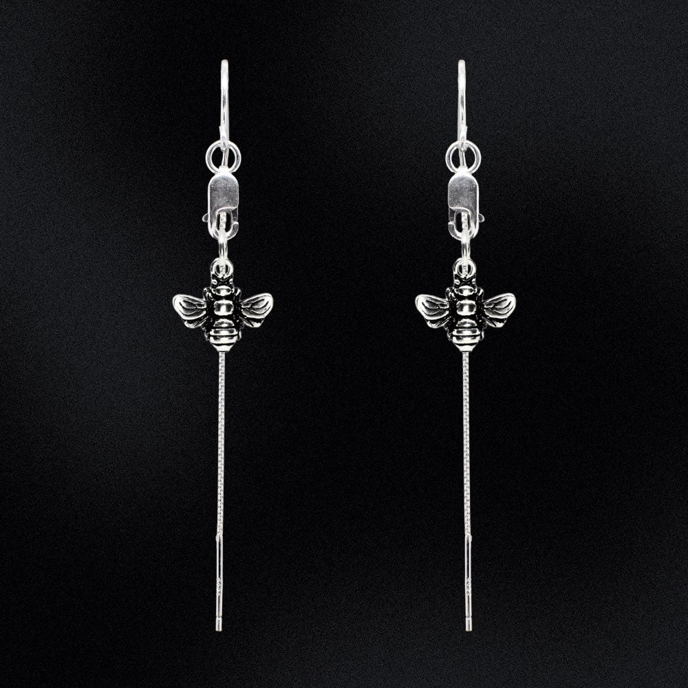 Let it Bee - Silver Thread Earrings are the perfect addition to any wardrobe. Crafted from sterling silver, they feature a delicate bee charm, suspended from a lobster clasp and lightweight threaders, making them a timeless and elegant choice. They are comfortable to wear and guaranteed to start a conversation. Add a modern touch to your look with this stunning piece of jewellery that is perfect for everyday or a special night out.