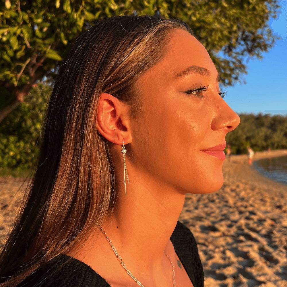 Take a stroll on the beachy side with these adorable Sea Shell & Chain Threader Earrings. These threaders add the perfect touch of whimsy to any outfit, and they're sure to lead to an ocean of compliments! Who knew shells and chains could be so stylish?!  These earrings are lightweight and easy to wear, making them perfect for those who are always on the go. Handmade from Sterling Silver.