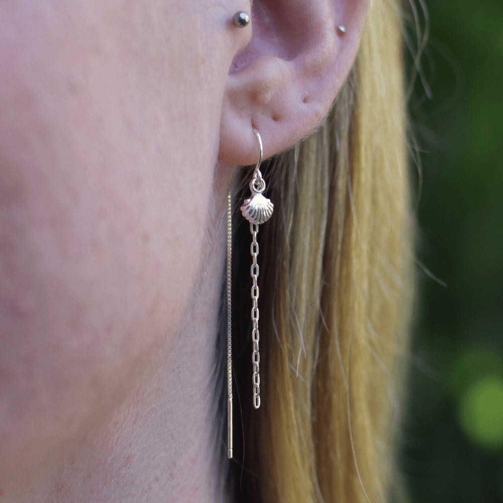 Take a stroll on the beachy side with these adorable Sea Shell & Chain Threader Earrings. These threaders add the perfect touch of whimsy to any outfit, and they're sure to lead to an ocean of compliments! Who knew shells and chains could be so stylish?!  These earrings are lightweight and easy to wear, making them perfect for those who are always on the go. Handmade from Sterling Silver.
