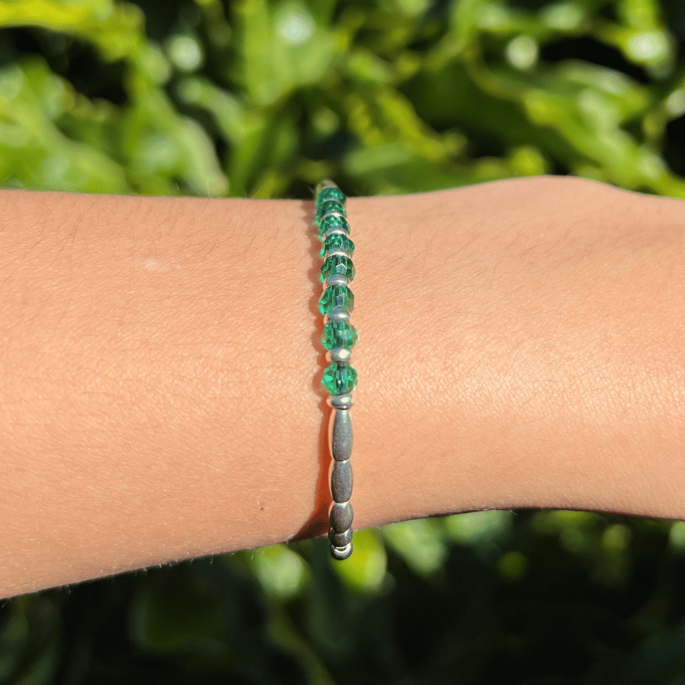 Introducing the Emerald Essence Silver Beaded Bracelet - the perfect accessory to complete any outfit. The centre detail of the bracelet features stunning faceted glass rondelle green beads that catch the light and sparkle brilliantly. Surrounding these gems are delicate silver beads, adding a touch of sophistication and elegance to the design.