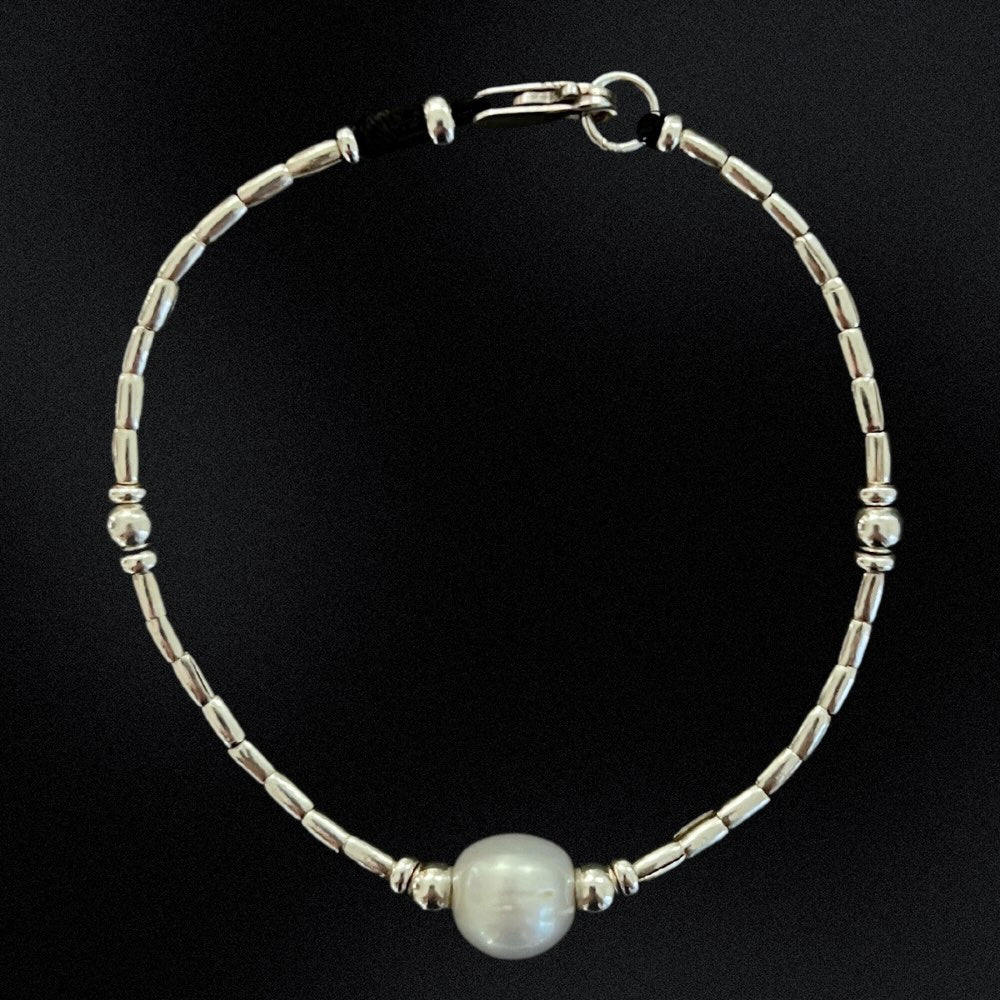 Introducing our Hill Tribe Silver & Pearl Bracelet, a fusion of tradition and elegance. Meticulously handcrafted in Australia, this bracelet features a central freshwater pearl embraced by intricate silver beads.  The pearl, symbolising purity and timeless beauty, adds sophistication. Finished with a lobster clasp, this piece is versatile for any occasion, blending cultural heritage with refined style. Elevate your look with this timeless treasure.