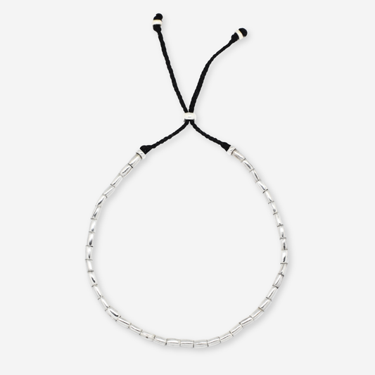 Silver beaded bracelet with black cord on a white background