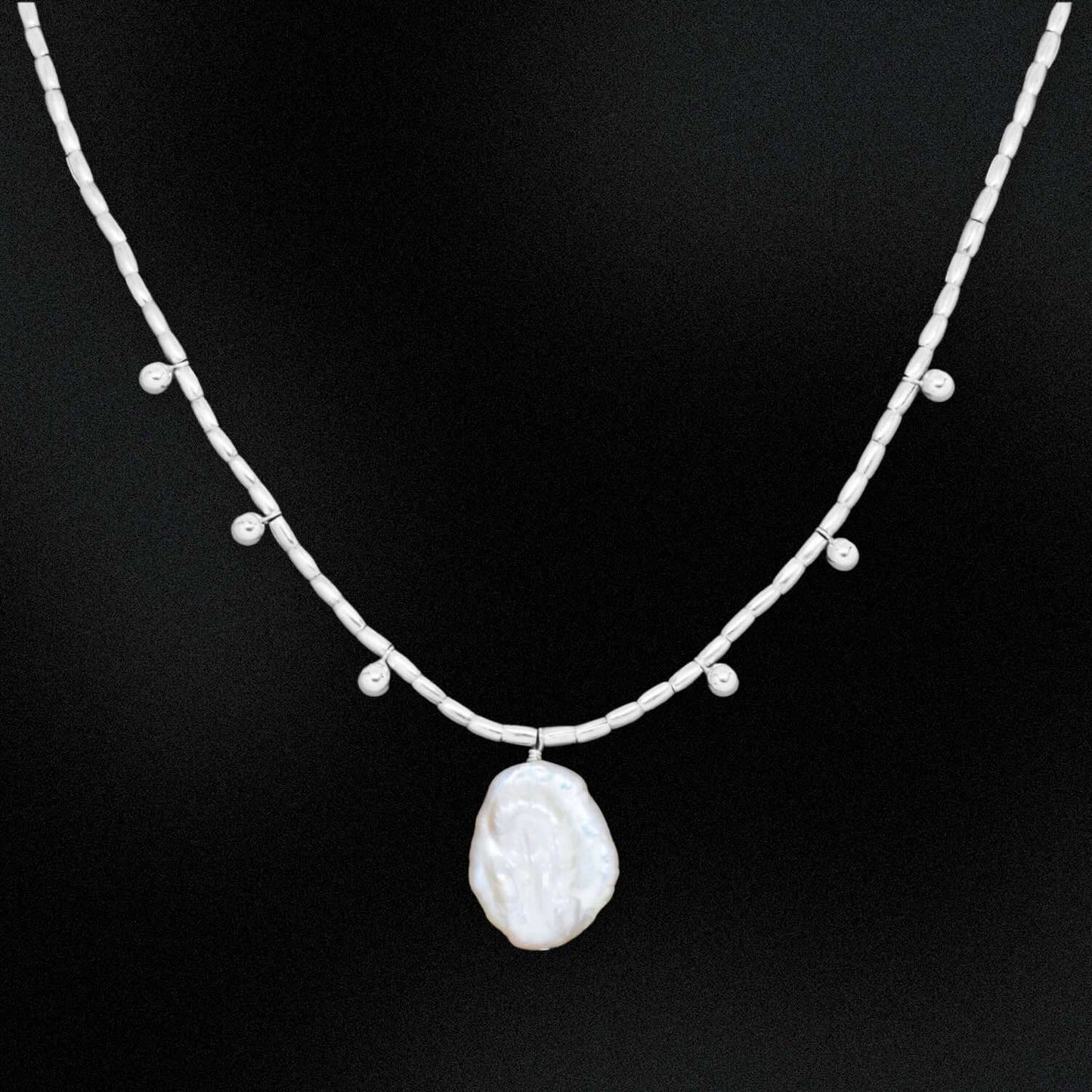 Necklace with a large pearl pendant on a black background