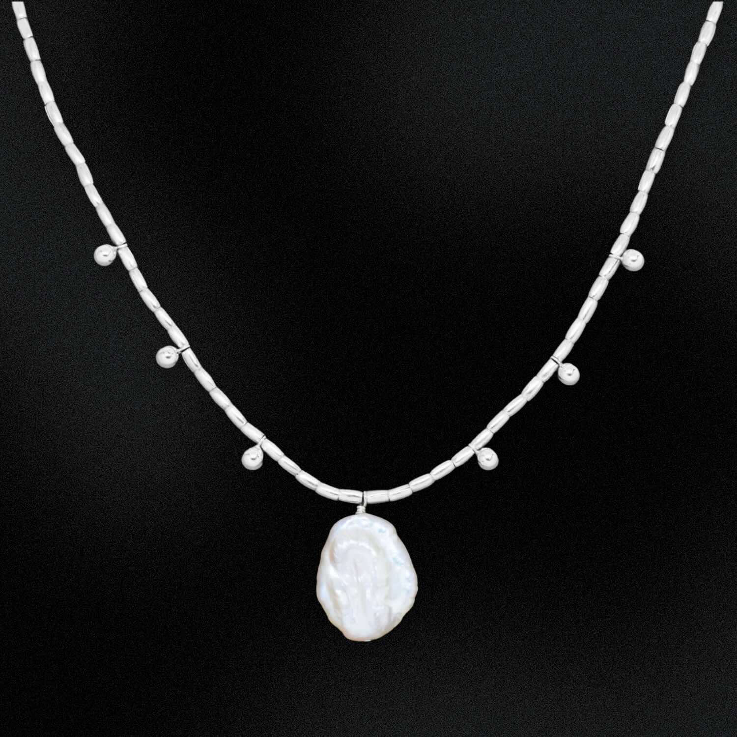 Necklace with a large pearl pendant on a black background